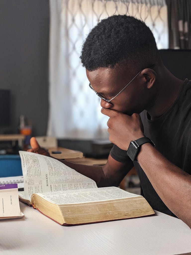 Young man deeply engaged in reading a bible